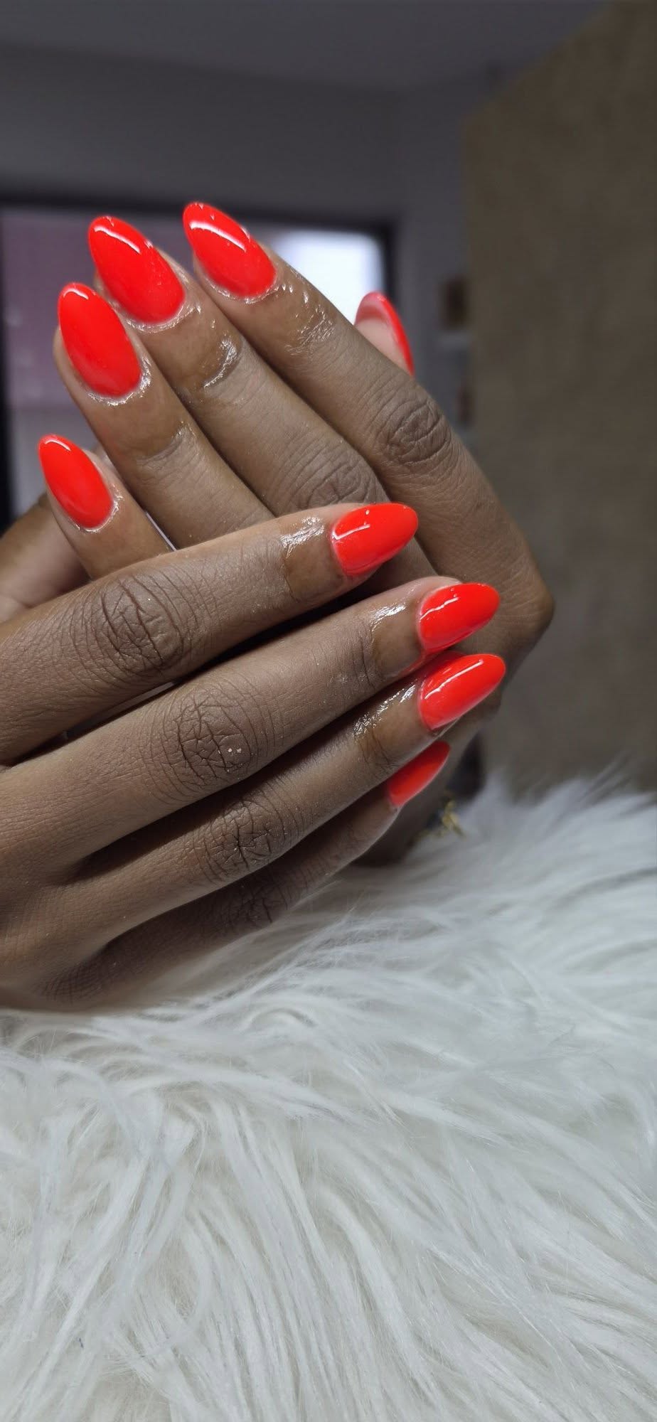 Bright orange-red almond nails, professionally sculpted